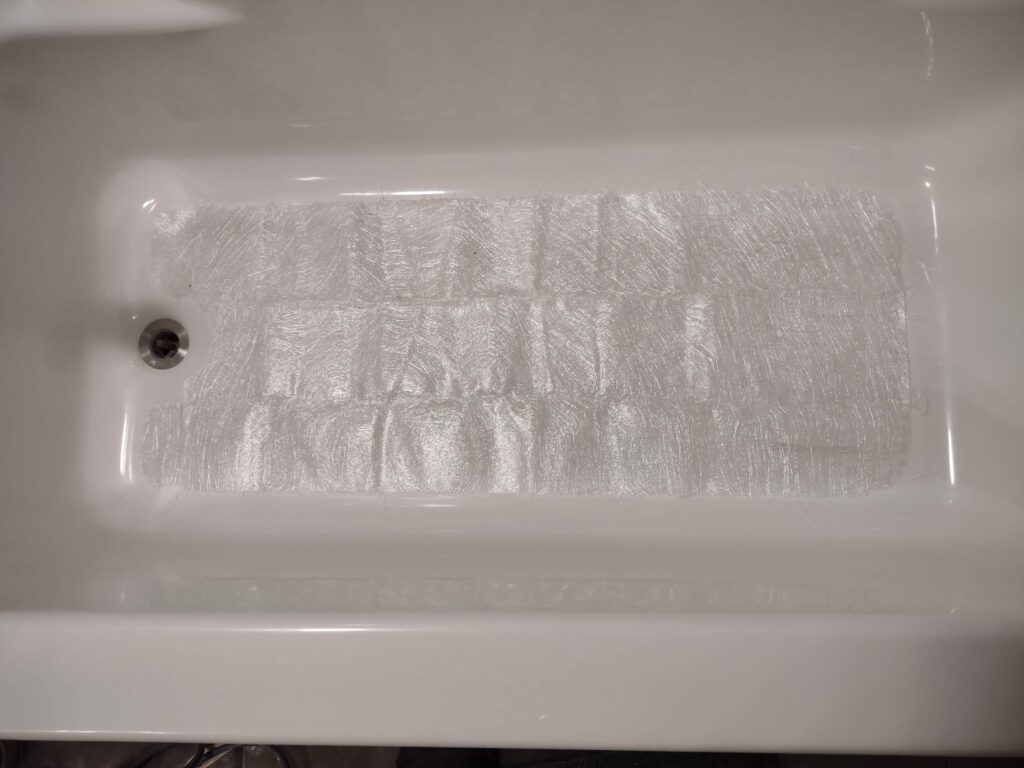fitting the fiberglass mat to the tub bottom